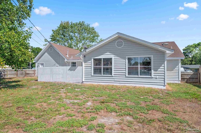 rear view of property with a lawn