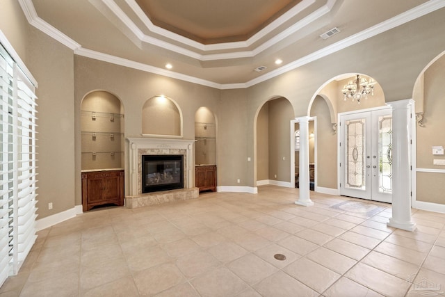 unfurnished living room with ornate columns, a tray ceiling, light tile patterned flooring, ornamental molding, and recessed lighting
