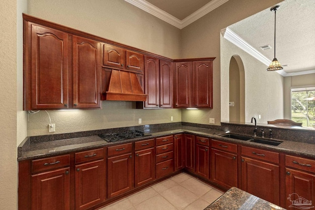 kitchen with custom range hood, a sink, gas cooktop, crown molding, and dark brown cabinets