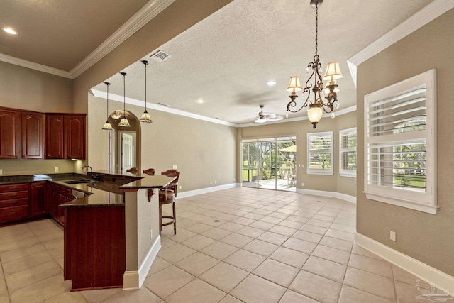 kitchen with a textured ceiling, open floor plan, a breakfast bar area, a peninsula, and light tile patterned floors