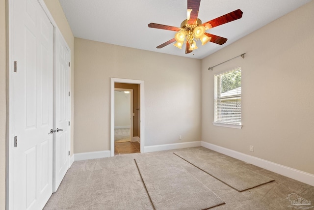 unfurnished bedroom with carpet flooring, a closet, ceiling fan, and baseboards