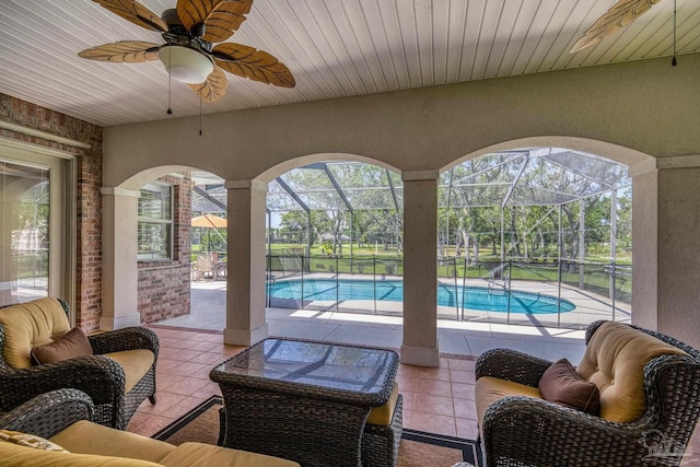 view of patio with an outdoor pool, ceiling fan, and glass enclosure
