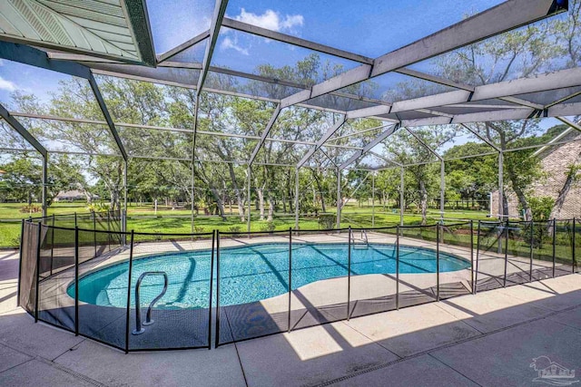 swimming pool featuring a patio area, view of wooded area, a lawn, and a lanai