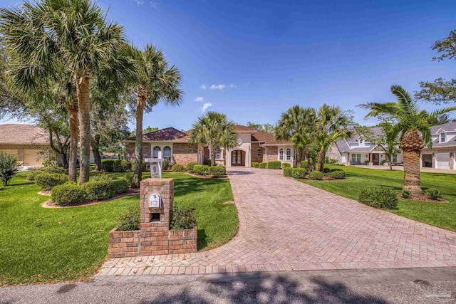 mediterranean / spanish house with decorative driveway and a front yard