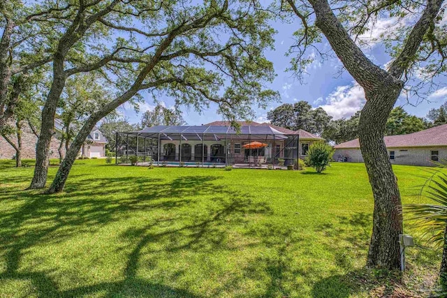 rear view of property featuring a yard, a lanai, and a pool