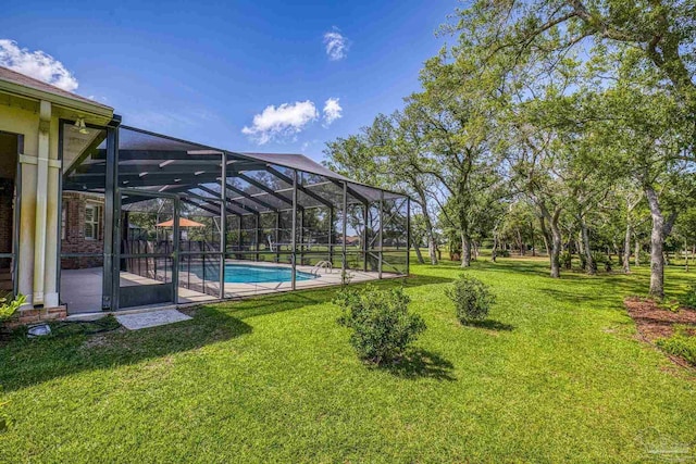 view of green lawn with an outdoor pool and a patio