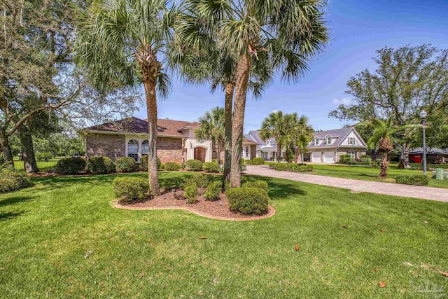 view of front of property featuring curved driveway and a front lawn