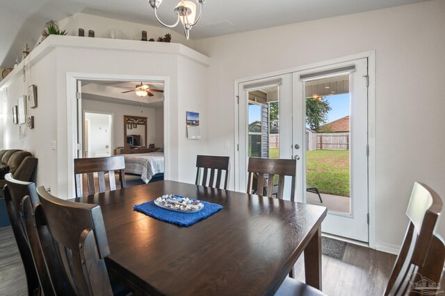 dining room featuring dark wood-type flooring, ceiling fan with notable chandelier, and french doors