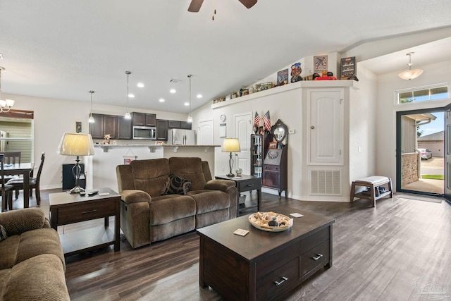 living room featuring lofted ceiling, hardwood / wood-style floors, and ceiling fan with notable chandelier