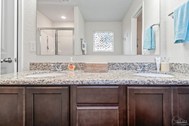 bathroom with vanity and a shower with shower door