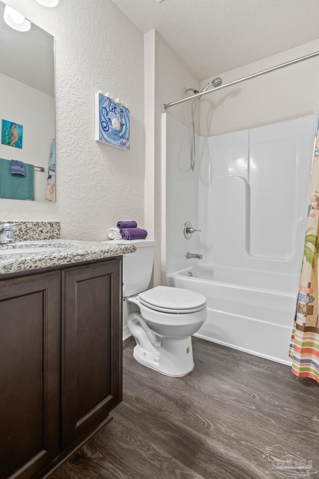 full bathroom featuring a textured ceiling, vanity, wood-type flooring, toilet, and shower / bath combo with shower curtain