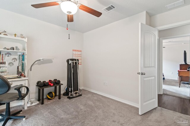 carpeted home office with ceiling fan