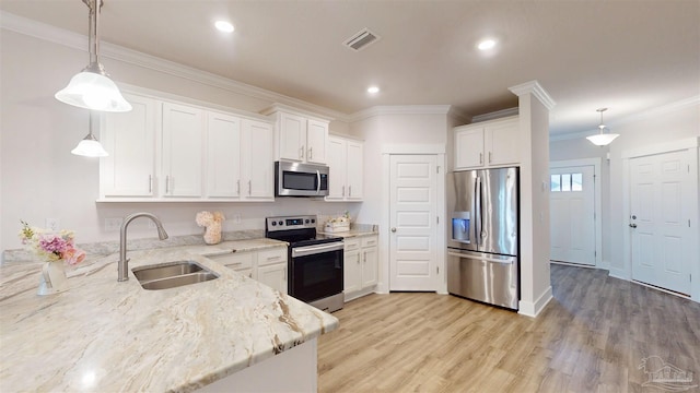 720 Brambling Ct, Cantonment, FL 32533 - kitchen with appliances with stainless steel finishes, a sink, white cabinets, ornamental molding, and light stone countertops