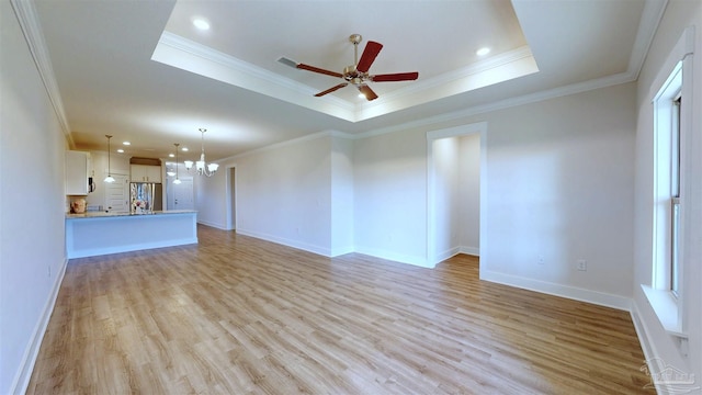 720 Brambling Ct, Cantonment, FL 32533 - unfurnished living room featuring a chandelier, light wood-style flooring, a raised ceiling, crown molding, and ceiling fan
