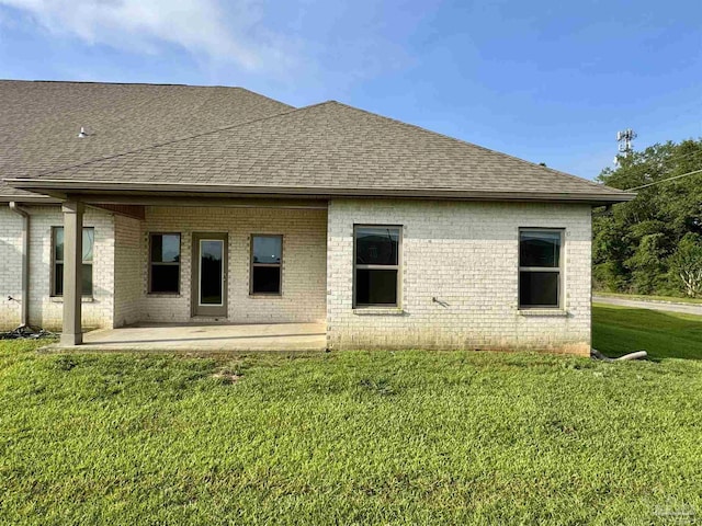 720 Brambling Ct, Cantonment, FL 32533 - back of property featuring roof with shingles, a patio area, brick siding, and a lawn