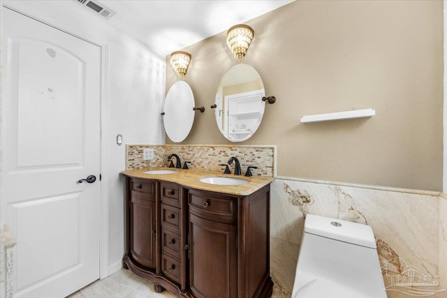 bathroom with tile walls, vanity, and toilet