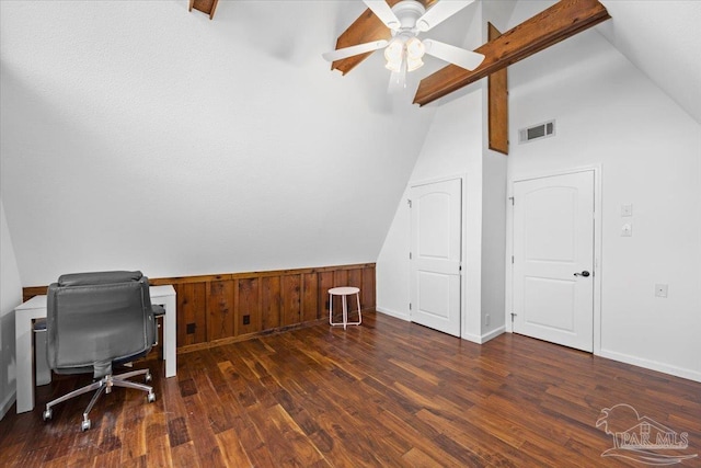 office space featuring dark hardwood / wood-style flooring, ceiling fan, wooden walls, and lofted ceiling with beams