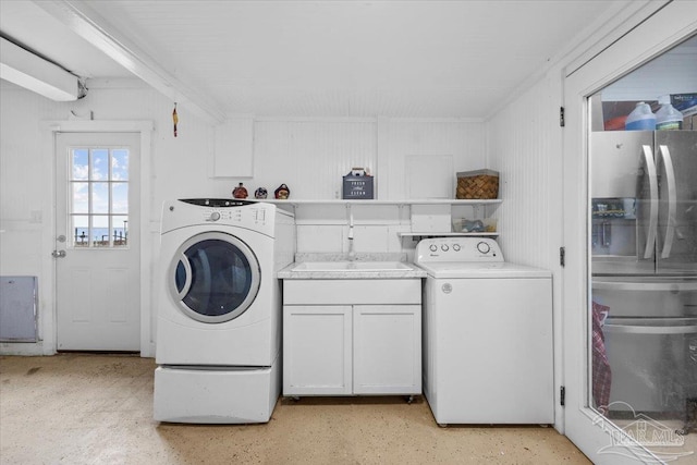 clothes washing area featuring cabinets and sink