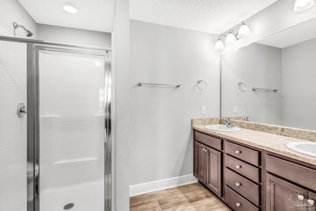 6004 Royal Port Ct, Pensacola, FL 32526 - bathroom with double vanity, a shower stall, and wood finished floors