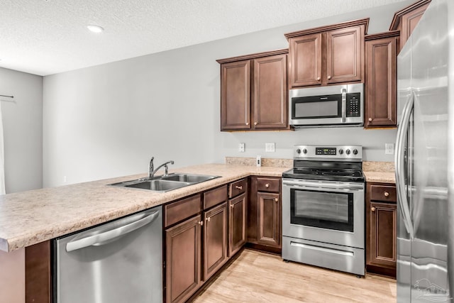 6004 Royal Port Ct, Pensacola, FL 32526 - kitchen with stainless steel appliances, light wood finished floors, a peninsula, light countertops, and a textured ceiling