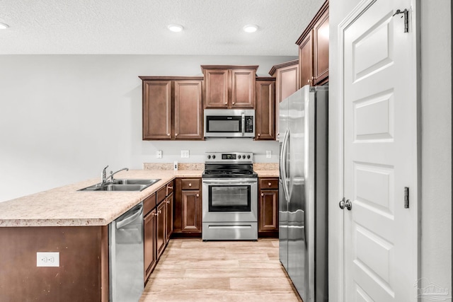 6004 Royal Port Ct, Pensacola, FL 32526 - kitchen featuring stainless steel appliances, light wood-type flooring, a peninsula, a textured ceiling, and light countertops