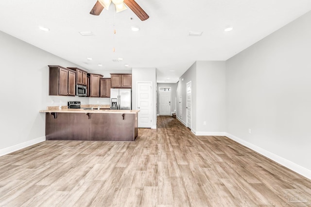 6004 Royal Port Ct, Pensacola, FL 32526 - kitchen with stainless steel appliances, a peninsula, a ceiling fan, light countertops, and light wood-style floors