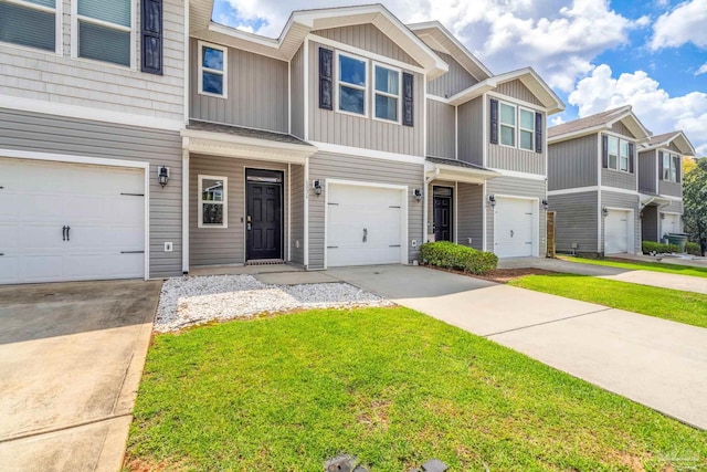 6004 Royal Port Ct, Pensacola, FL 32526 - townhome / multi-family property with a front yard, concrete driveway, an attached garage, and board and batten siding