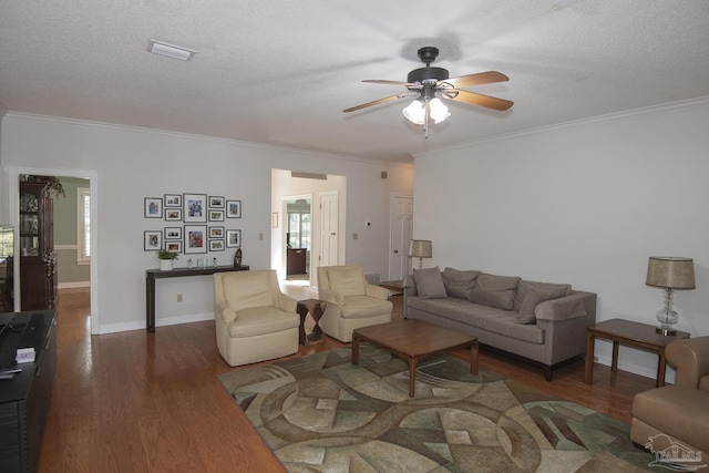 living room featuring ceiling fan, dark hardwood / wood-style flooring, ornamental molding, and a textured ceiling