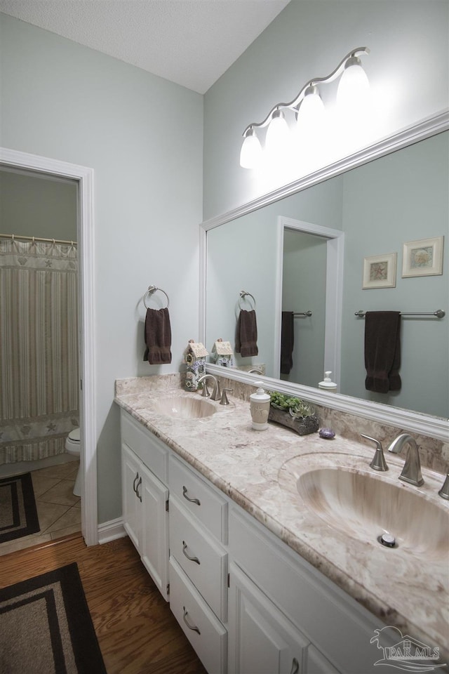 bathroom featuring toilet, vanity, and hardwood / wood-style flooring