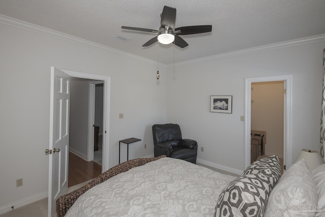 bedroom with a textured ceiling, light colored carpet, ceiling fan, and ornamental molding