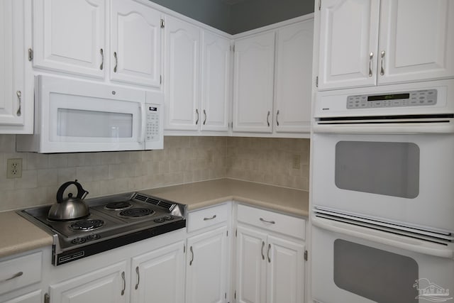 kitchen featuring white cabinets, white appliances, and backsplash