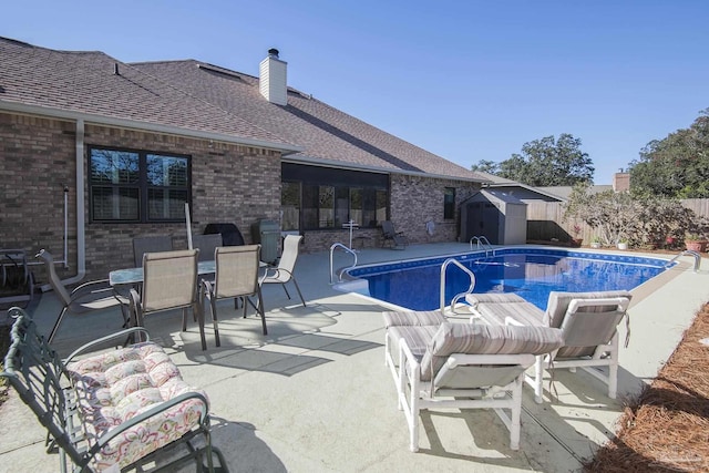 view of pool with a storage unit and a patio area