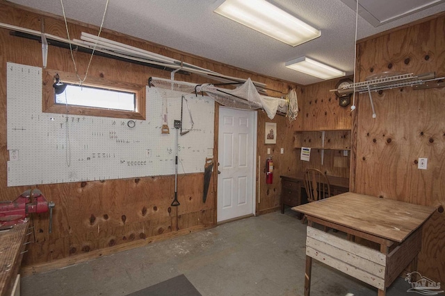 basement with a workshop area and wooden walls