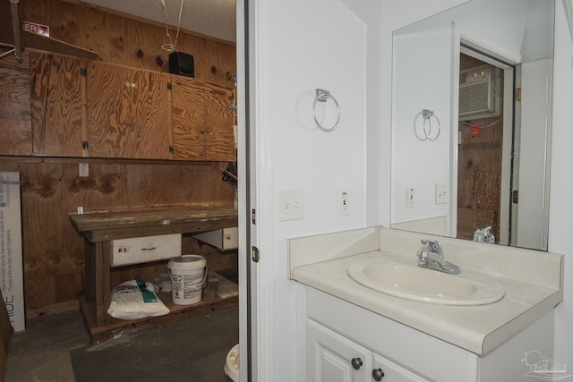 bathroom featuring wooden walls, vanity, concrete floors, and a textured ceiling