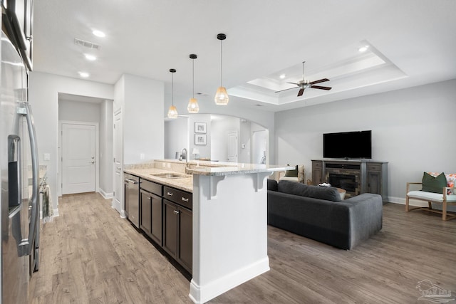 7908 Majestic Cypress Dr, Milton, FL 32583 - kitchen featuring light stone counters, a sink, arched walkways, a ceiling fan, and visible vents