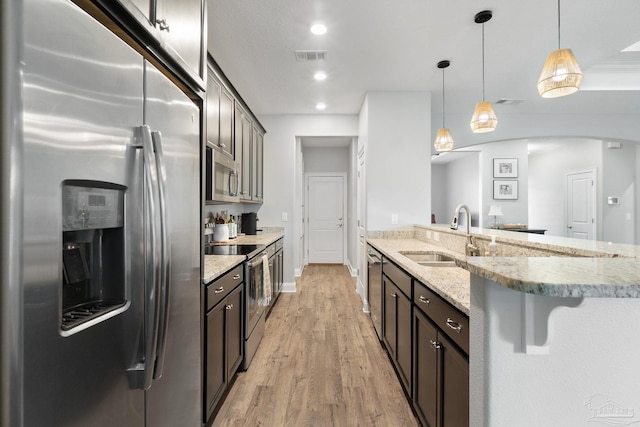 7908 Majestic Cypress Dr, Milton, FL 32583 - kitchen featuring visible vents, light stone countertops, a sink, light wood finished floors, and stainless steel appliances