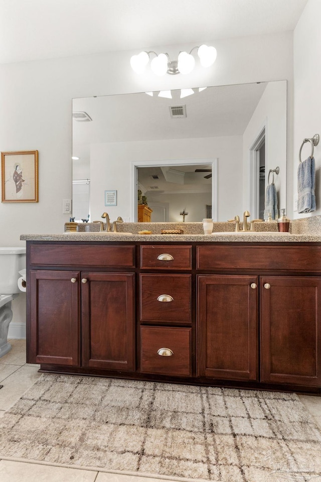 bathroom featuring double vanity, visible vents, toilet, and a sink