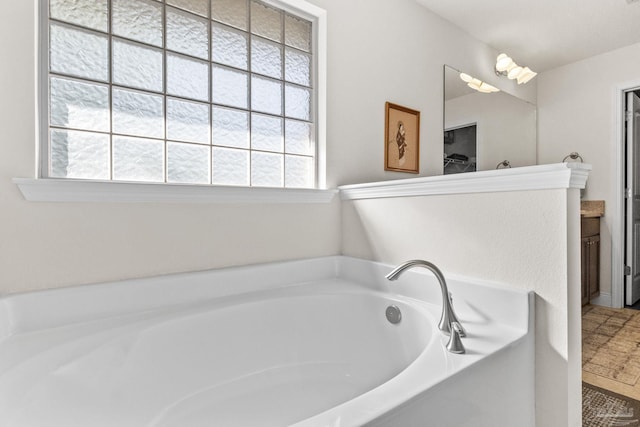bathroom featuring a garden tub and vanity