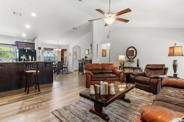 living room featuring recessed lighting, lofted ceiling, visible vents, light wood-style flooring, and ceiling fan with notable chandelier
