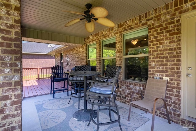 view of patio featuring outdoor dining area, ceiling fan, and a deck