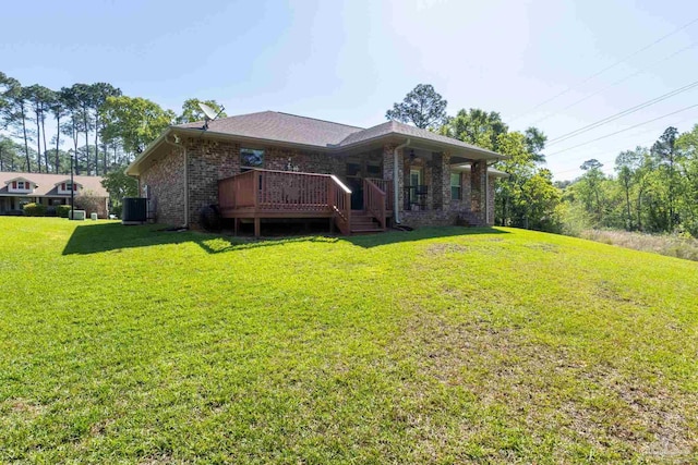 rear view of house with central AC, brick siding, a yard, and a deck