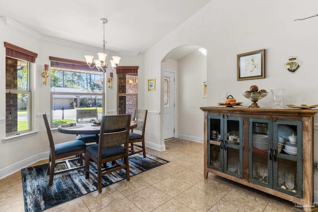 dining space with arched walkways, baseboards, light tile patterned flooring, and an inviting chandelier