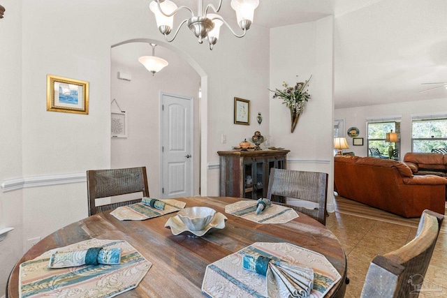 dining space with arched walkways and a notable chandelier