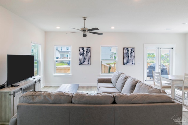 living room featuring light hardwood / wood-style flooring, ceiling fan, and a wealth of natural light