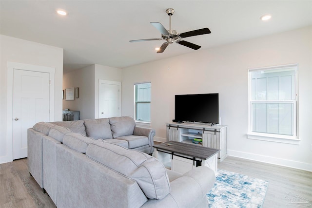 living room with ceiling fan and light hardwood / wood-style flooring