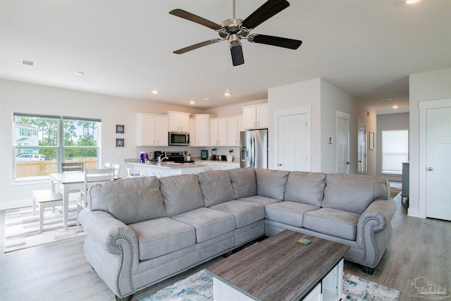 living room with ceiling fan and light wood-type flooring