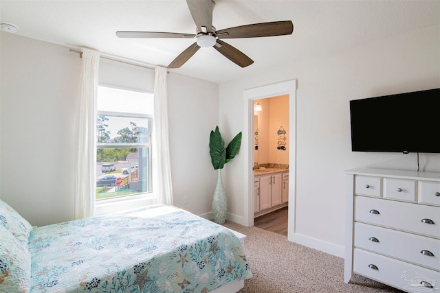 carpeted bedroom with ceiling fan and ensuite bathroom