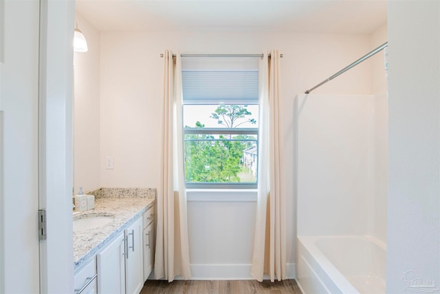 bathroom featuring shower / bathtub combination, vanity, and wood-type flooring