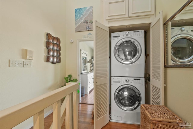 washroom with light hardwood / wood-style floors and stacked washer and clothes dryer