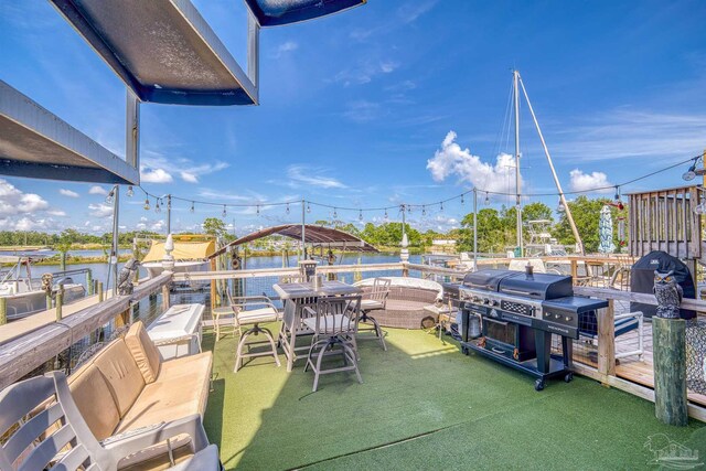 view of patio with a water view, a boat dock, and a grill